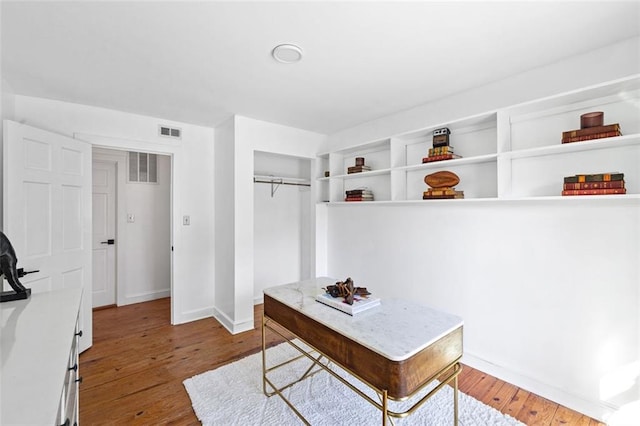 office featuring wood finished floors, visible vents, and baseboards