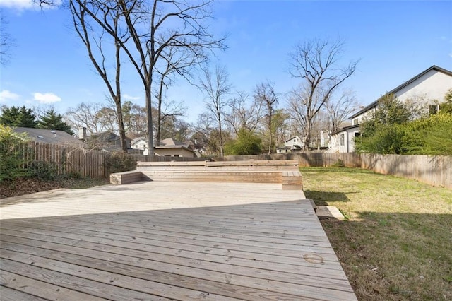 wooden terrace featuring a yard, a residential view, and a fenced backyard