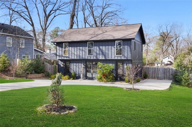 rear view of house with a yard and fence