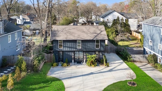 view of front facade featuring a residential view, driveway, and fence