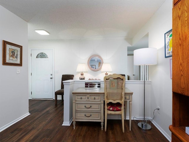 home office with dark hardwood / wood-style flooring and a textured ceiling