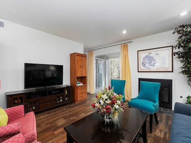 living room with dark wood-type flooring and a textured ceiling