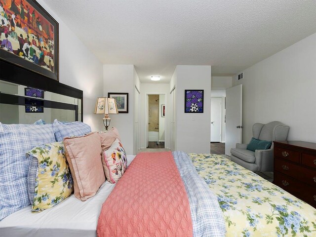 bedroom featuring connected bathroom and a textured ceiling