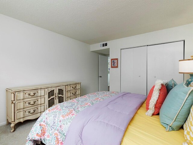 bedroom featuring carpet floors, a closet, and a textured ceiling