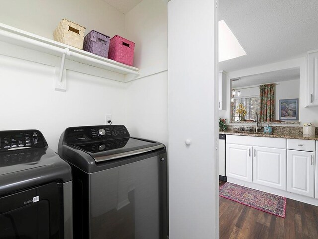 clothes washing area with dark hardwood / wood-style flooring, sink, and washing machine and dryer