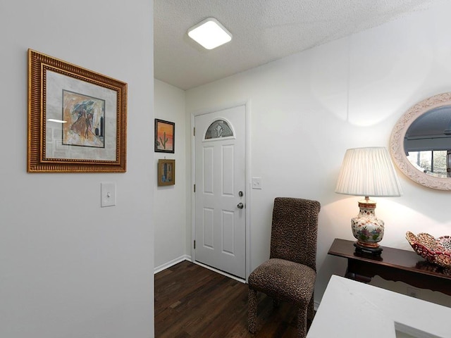 foyer with dark hardwood / wood-style flooring and a textured ceiling