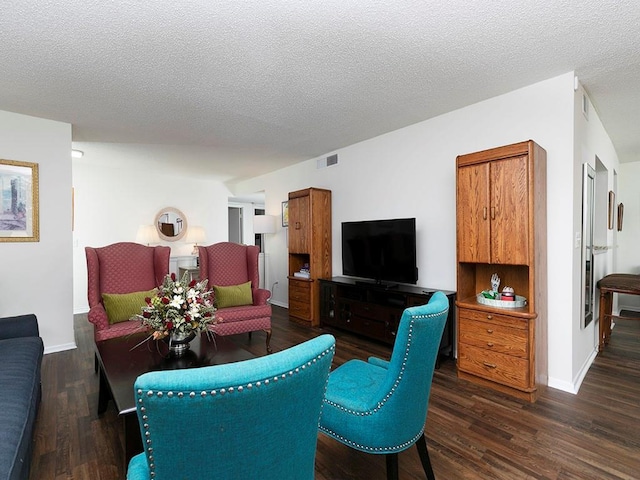 living room with dark hardwood / wood-style flooring and a textured ceiling