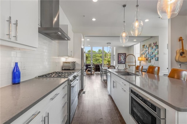 307 Cedar Dust Dr, Decatur, GA 30030 - kitchen with wall chimney range hood, appliances with stainless steel finishes, dark wood-style floors, backsplash, and white cabinets