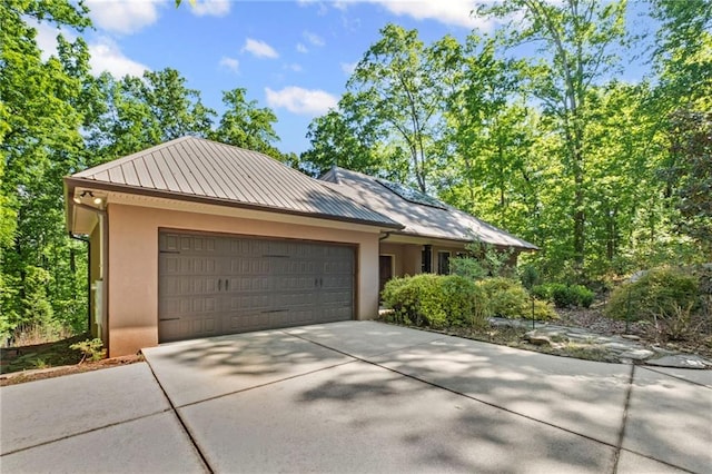 6324 Chesla Dr, Gainesville, GA 30506 - view of front of home featuring a standing seam roof, stucco siding, a garage, concrete driveway, and metal roof