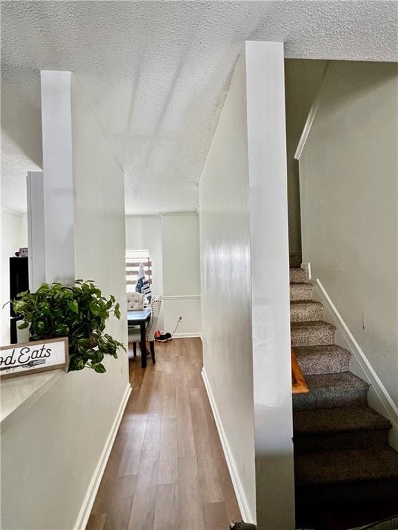 1731 Pryor Rd SW Unit 307, Atlanta, GA 30315 - staircase featuring a textured ceiling and wood finished floors