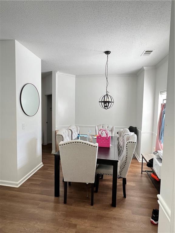 1731 Pryor Rd SW Unit 307, Atlanta, GA 30315 - dining area featuring wood finished floors, a textured ceiling, and ornamental molding