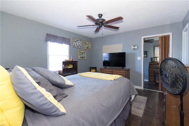 bedroom featuring dark wood-style floors, ceiling fan, baseboards, and a textured ceiling