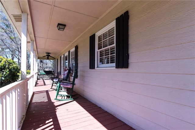 wooden deck with a porch and visible vents