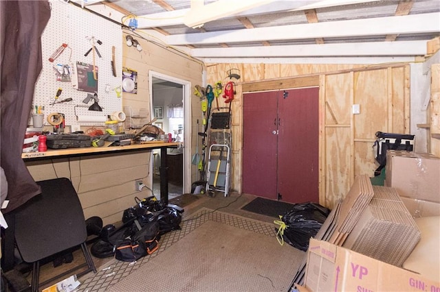 interior space featuring lofted ceiling, wooden walls, and a workshop area