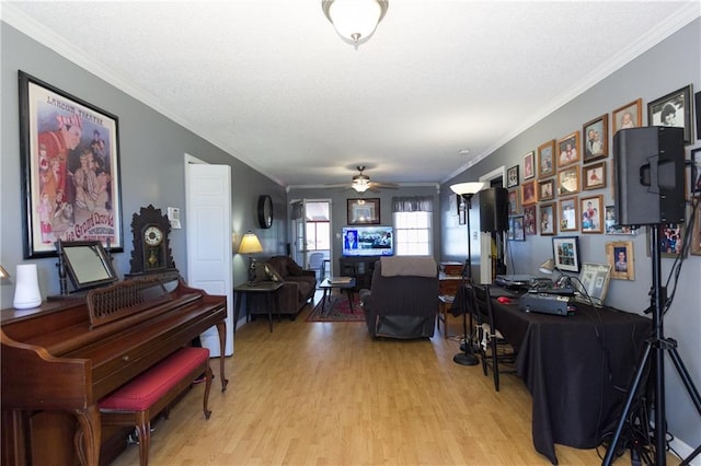 interior space with ceiling fan, crown molding, a textured ceiling, and wood finished floors