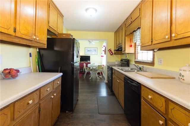 kitchen featuring brown cabinetry, light countertops, a sink, and black appliances