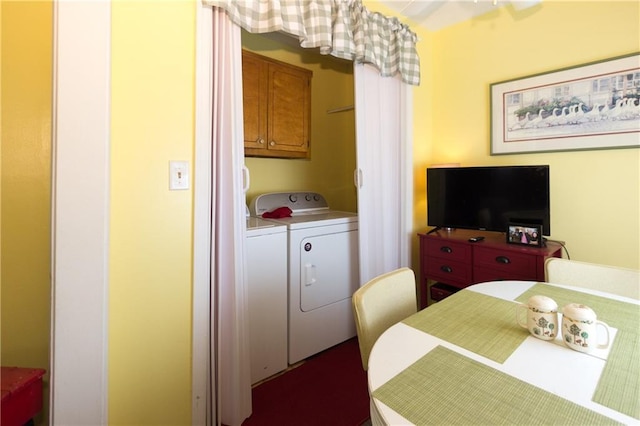 clothes washing area featuring cabinet space and washer and clothes dryer