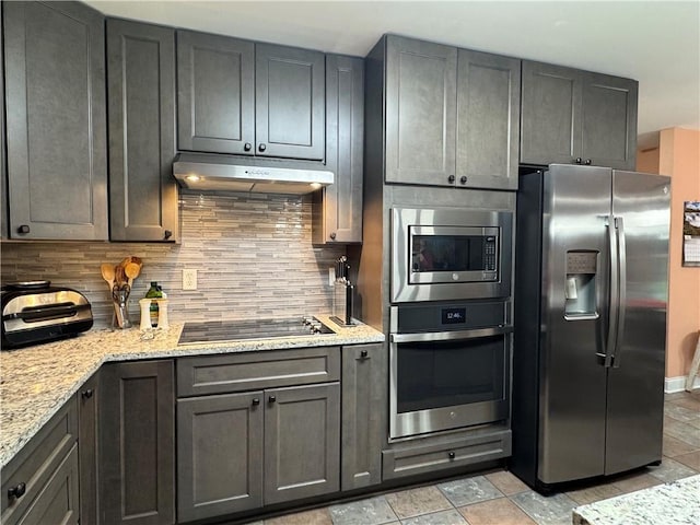 714 Arden Dr, Winder, GA 30680 - kitchen with stainless steel appliances, under cabinet range hood, decorative backsplash, light stone counters, and light stone finish flooring