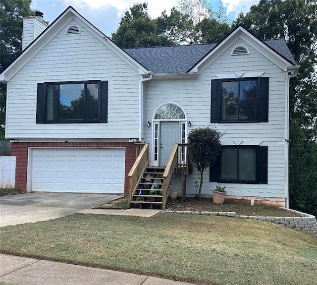 raised ranch featuring a front yard and a garage