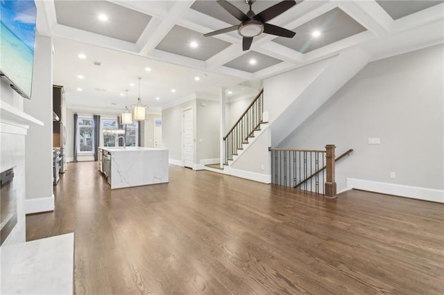 living area featuring beam ceiling, coffered ceiling, recessed lighting, baseboards, and dark wood-style flooring