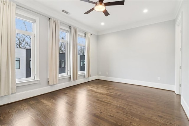 unfurnished room featuring crown molding, plenty of natural light, visible vents, and dark wood-type flooring