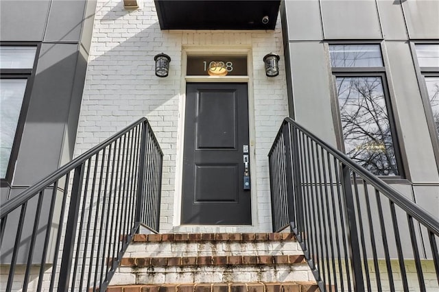 entrance to property featuring brick siding