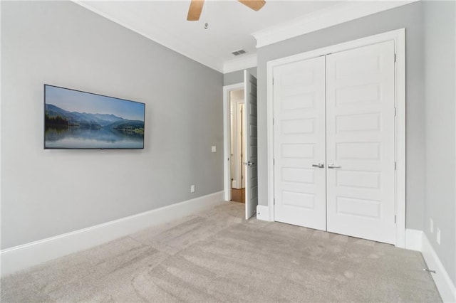 unfurnished bedroom featuring visible vents, carpet floors, baseboards, and crown molding