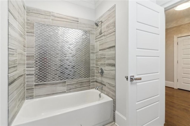 full bathroom featuring baseboards, wood finished floors, and bathtub / shower combination