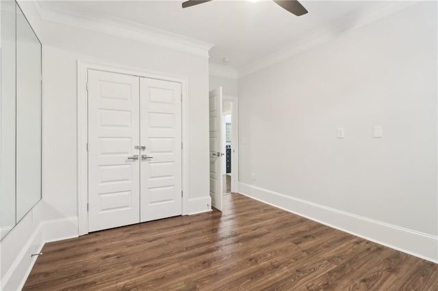 unfurnished bedroom featuring ornamental molding, a ceiling fan, wood finished floors, a closet, and baseboards