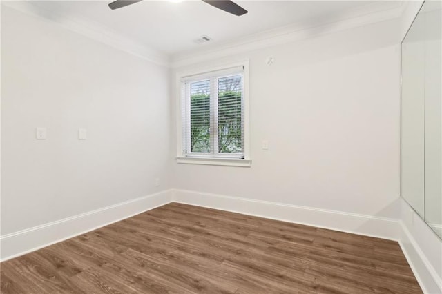 unfurnished room with a ceiling fan, wood finished floors, baseboards, visible vents, and crown molding