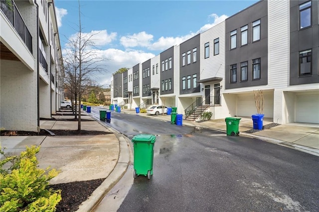 view of road with curbs, a residential view, and sidewalks