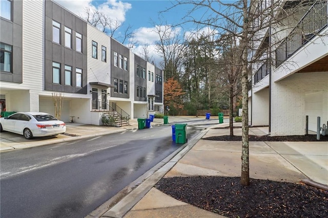 view of street with curbs, a residential view, and sidewalks