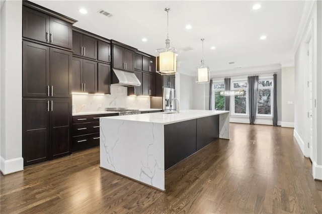 kitchen with visible vents, a spacious island, decorative backsplash, dark brown cabinets, and under cabinet range hood