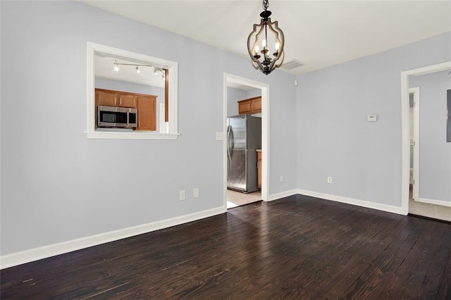 unfurnished room featuring wood-type flooring and a chandelier