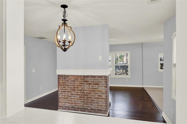 foyer with dark wood-type flooring and an inviting chandelier