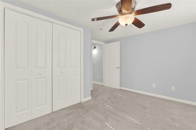 unfurnished bedroom featuring light carpet, a closet, and ceiling fan