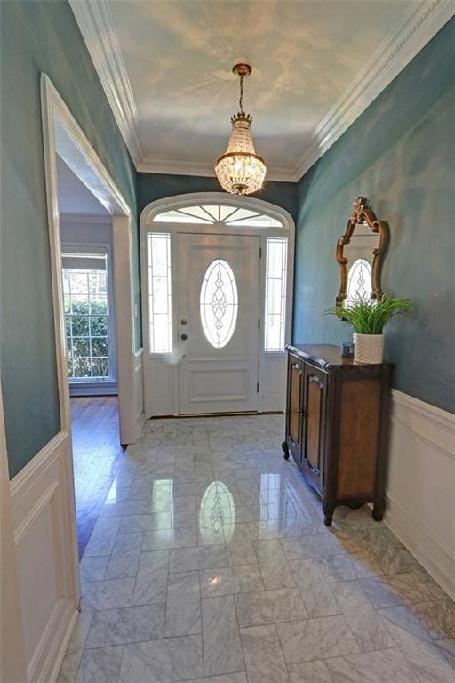 tiled entrance foyer with a notable chandelier and ornamental molding