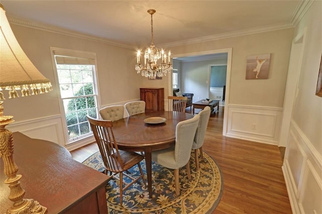 dining space with a chandelier, ornamental molding, and hardwood / wood-style flooring