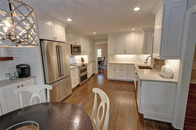 kitchen featuring tasteful backsplash, dark wood-type flooring, high quality appliances, sink, and white cabinets