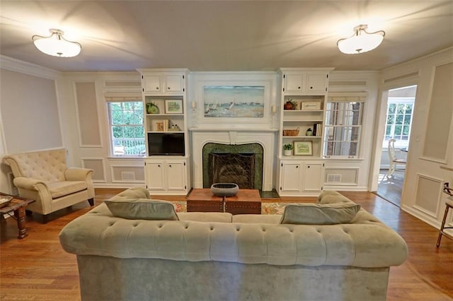 living room with crown molding and light wood-type flooring