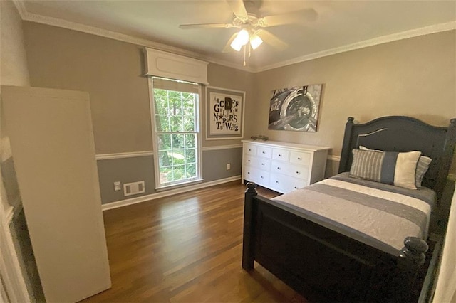 bedroom featuring dark hardwood / wood-style flooring, ceiling fan, and crown molding