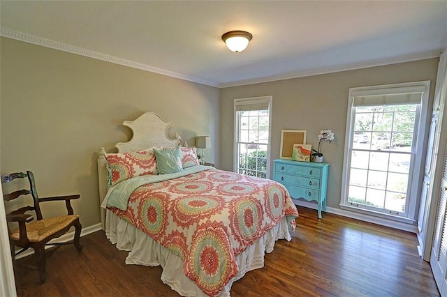 bedroom featuring dark hardwood / wood-style flooring, multiple windows, and crown molding