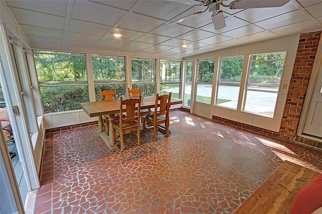 sunroom with a paneled ceiling, a healthy amount of sunlight, vaulted ceiling, and ceiling fan