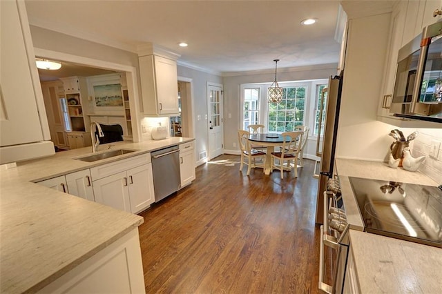 kitchen featuring white cabinets, pendant lighting, appliances with stainless steel finishes, and sink