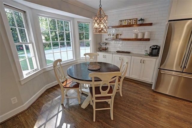 dining room with ornamental molding, dark wood-type flooring, and an inviting chandelier