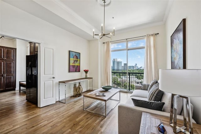 living room featuring a notable chandelier, wood-type flooring, and crown molding