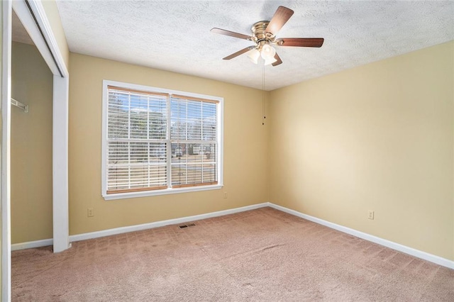 unfurnished room featuring carpet floors, visible vents, and baseboards