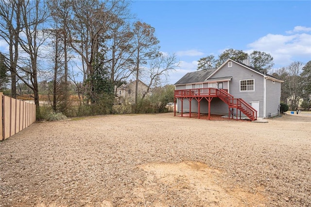 rear view of property with stairs, fence, and a wooden deck