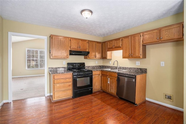 kitchen with under cabinet range hood, a sink, brown cabinets, dishwasher, and black gas range oven