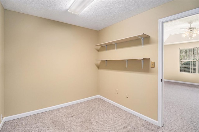 clothes washing area with carpet, a textured ceiling, and baseboards